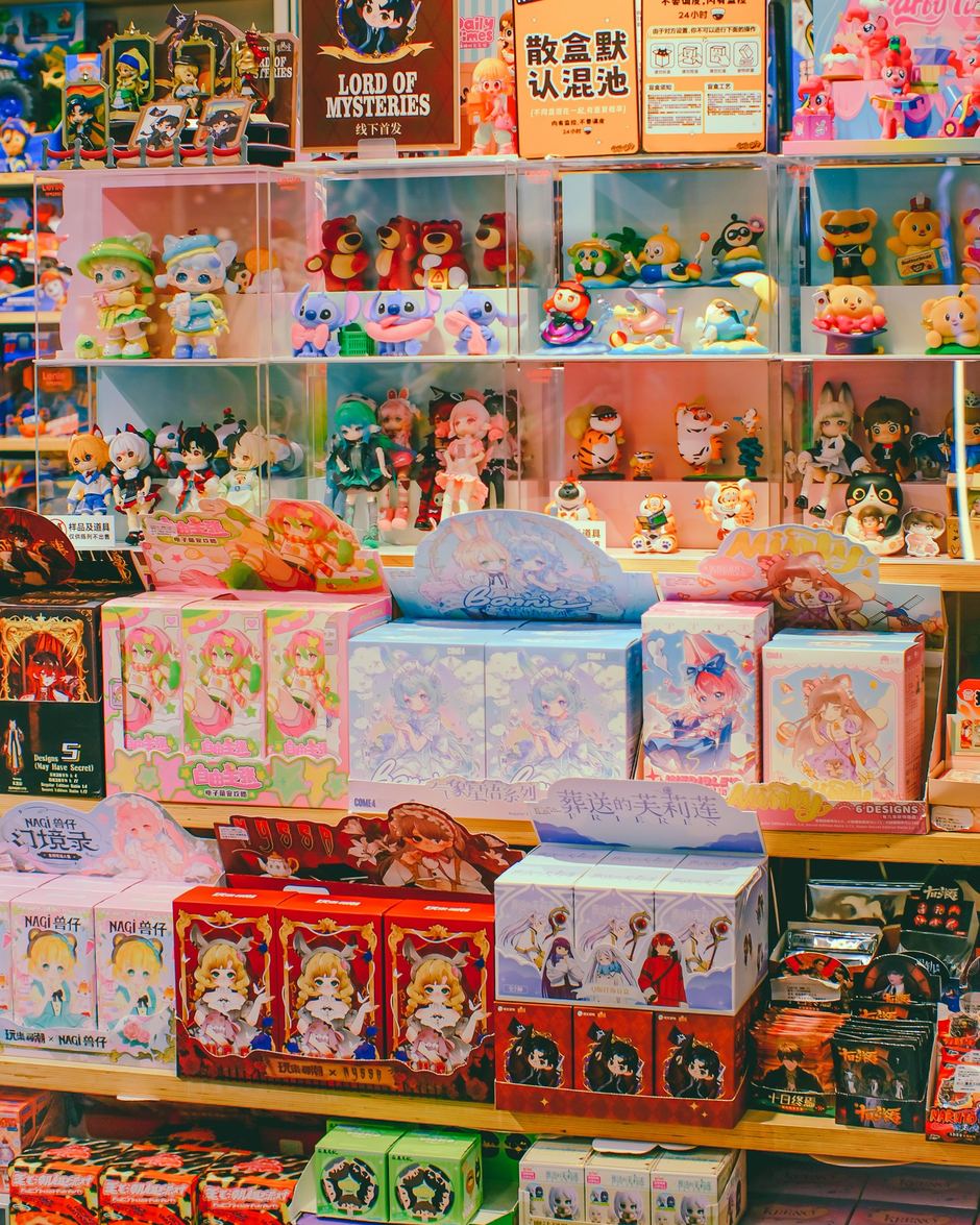 A shelf of collectible anime figures and blind boxes in a store
